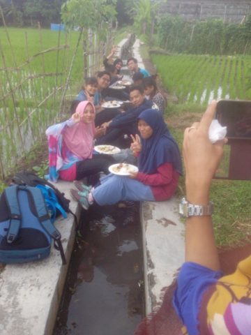 Peserta makan dipinggir sawah